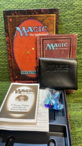 1995 Magic The Gathering Revised Box containing players guide, with stone pieces, and Magic bag