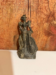 vintage pewter or bronze statue of a woman riding a bicycle