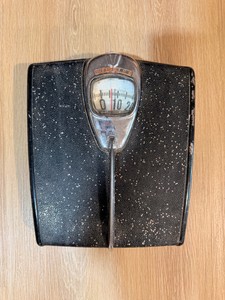 1950 Detecto bathroom scale featuring a speckled black finish and a bubble glass dial