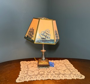 Vintage nautical-themed table lamp with doily