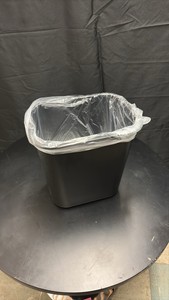 Black Plastic Garbage Bin About One Foot in Height, Comes With Roll of Garbage Bags