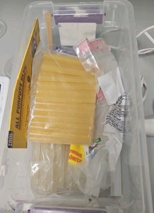 plastic container of glue and glue gun