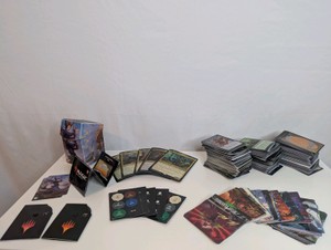 Unsorted Magic The Gathering cards, including various decks, stacks of sorted cards, and tokens or counters