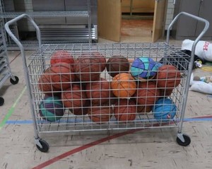 BASKETBALL CAGE ON WHEELS WITH LOTS OF BASKETBALLS