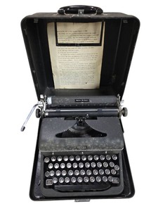vintage Royal Quiet De Luxe portable typewriter from the 1930s or 1940s, enclosed in its original black metal carrying case.