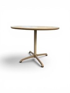 Steelcase bistro table featuring a light-colored laminate top and a beige four-star pedestal base
