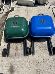 Portable charcoal grills, one green and one blue