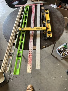Assorted Levels and Measuring Tools including Laser Level, Stanley Level, Metal T-Square, and Carpenter Levels