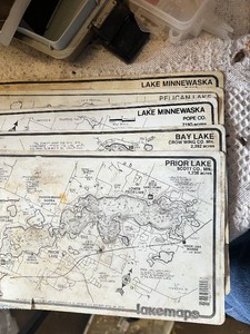 Maps, fishing guides, and fishing gear with binoculars and telescopes.