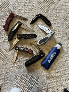 Knife collection including Gerber and Winchester knives, and a Sunnen honing stone
