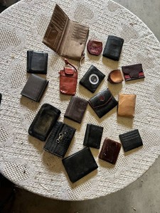 Lot of assorted wallets and small cases in various styles, materials, and colors including leather and fabric.