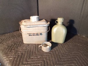 Vintage lunch box with cup fitting on top and a plastic canteen