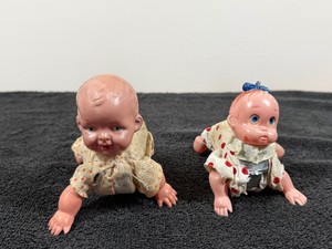 vintage wind-up celluloid crawling baby doll, typically manufactured in Japan or Germany between the 1920s and 1950s.