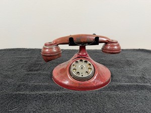 vintage metal toy rotary telephone, likely produced around the 1940s to 1950s.
