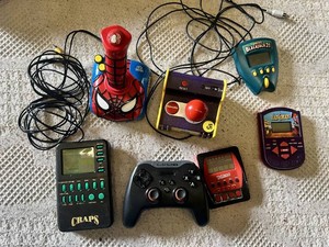Electronic Games and Controllers Assortment including SteelSeries Controller, Various Handheld Electronic Games, and Spiderman Plug-and-Play Joystick