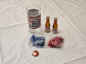 Budweiser and Bud Light Collectible includes a Bud Light glass, two miniature Budweiser bottles, and Bud-themed beaded necklaces in red and blue