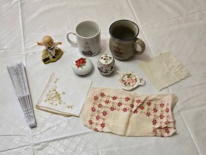 Decorative Collectibles and Mugs Including Minnesota Public Radio Mug, Ceramic Figurine, Embroidered Cloths and a Hand Fan