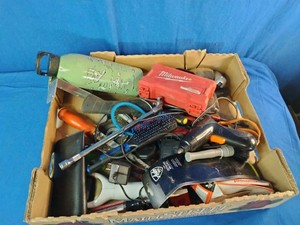 This box contains a mix of miscellaneous garage items, hand tools, small electronics, and personal care products.