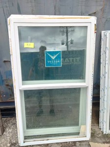 (2)  Vector brand white vinyl single-hung window featuring a prominent blue logo sticker on the glass.