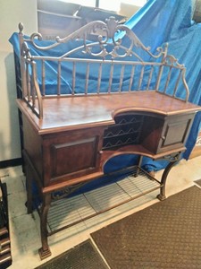 This French country-style bar console features a rich wood top and a decorative wrought iron frame