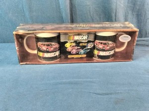 2005 NASCAR Flat-Out Mug Set featuring colorful stock car graphics and includes two coffee mugs.