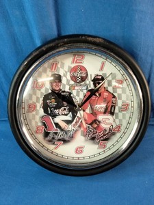 This vintage Coca-Cola NASCAR Dale Earnhardt Sr. and Jr. wall clock features signature branding and a glass lens.