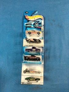 Stack of six carded Hot Wheels die-cast cars packaged from the late 1990s through the mid-2000s.