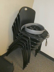 FIVE black stacking chairs