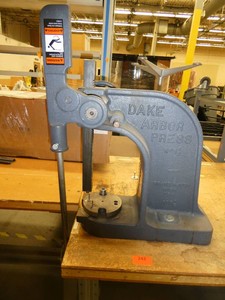 DAKE Arbor press 1-12 Ton mounted on a 72x36 workbench with wood top and steel legs, adjustable height