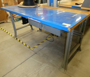 72x36 Workbench with wood top and steel legs, and a couple of drawers, top is covered with a plastic