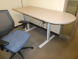 Adjustable height table with rounded end and office chair