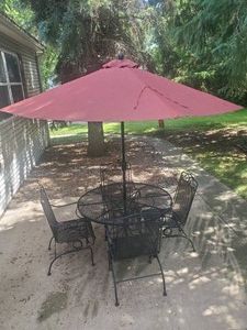 Lightly used Wrought iron patio set - 4 chairs with new cushions Table with umbrella and stand