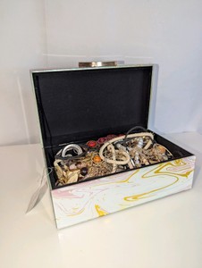 Marbled Jewelry box filled with unsorted, tangled Jewelry