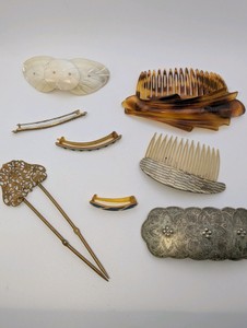 Vintage hair accessories, including combs, barrettes, and pins