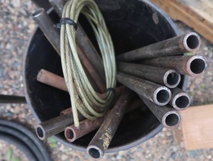BLACK 5 GAL BUCKET FULL OF BLACK METAL PIPES
