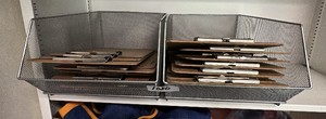 Two metal wire baskets, including lot of wood and metal clipboards