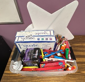 Container of games, pencils, markers, pens, puzzles, and more