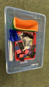 Container of dry erase markers, erasers, money, containers and rubbber floor mats.