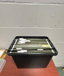 Plastic file cabinet with hanging folders.