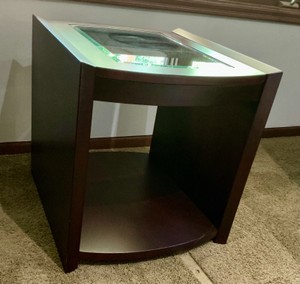 Modern side table with deep red, mahogany-toned finish and curved, tempered glass top