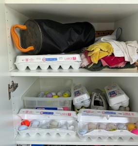 2 shelves of golf balls, golf ball cleaner and shoes