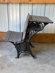late-19th to early-20th-century antique combination school desk, featuring an intricate scrollwork cast-iron frame and slatted wood surfaces