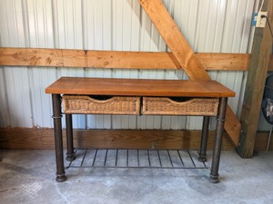 sofa console table featuring a dark metal pipe-style frame, a solid wood top, a wire lower shelf, and pull-out wicker storage baskets.