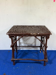 handmade rustic twig table features a top made of parallel branch sticks and a frame constructed from connected limbs