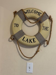 nautical-themed decorative lifebuoy featuring the phrase WELCOME TO THE LAKE.