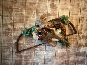 Decorative Ring-necked Pheasant wall mount featuring a taxidermy bird posed on a log with a vintage saw.