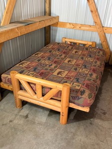 Wood framed futon with fly fishing decor on the cushion