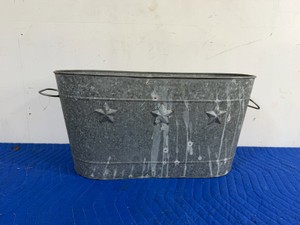 oval galvanized metal tub featuring embossed stars and side wire handles.
