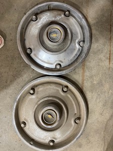 Two chevy hubcaps