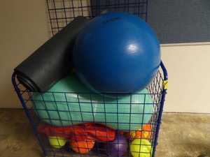 LARGE CAGE FULL OF ASSORTED BALLS AND AND YOGA MATTS